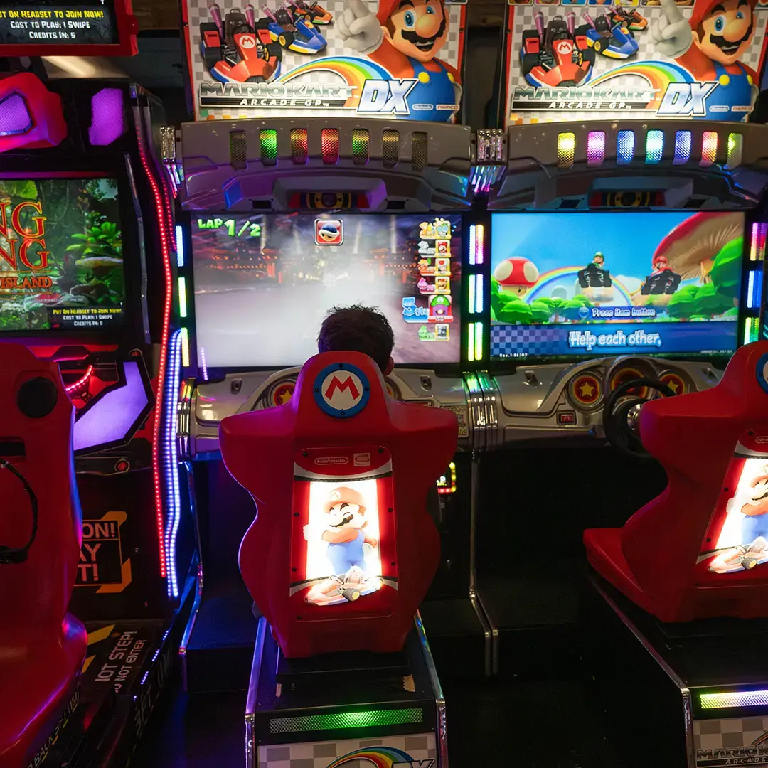 A teen playing Mario Kart in Indy Karting's arcade